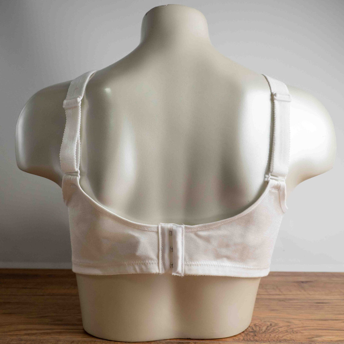Triumph white blend bra with delicate embroidery, adjustable straps, and hook-and-eye closure.