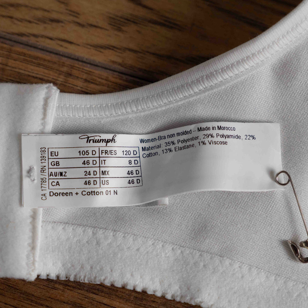 Triumph white blend bra with delicate embroidery, adjustable straps, and hook-and-eye closure.