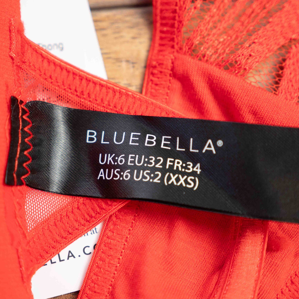 Bluebella red lace thong with elastic straps and brand tags attached.