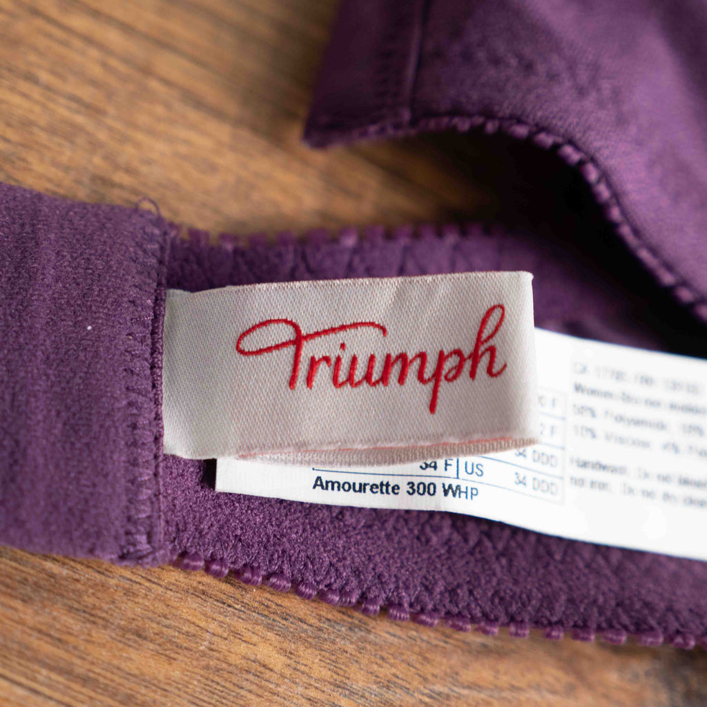 Triumph purple bra with floral lace pattern, adjustable straps, and hook-and-eye closure.