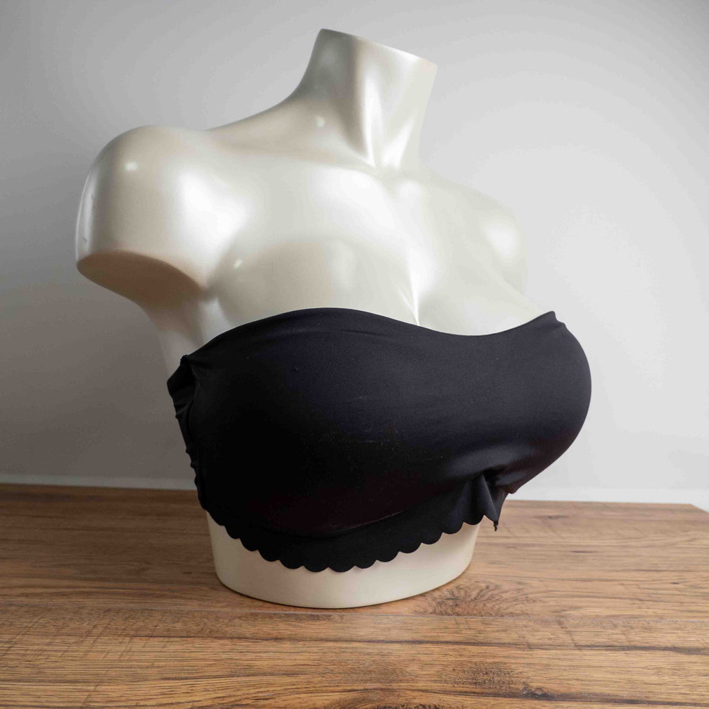 Next black strapless bandeau bra with scalloped hem and multiple hook back closure.