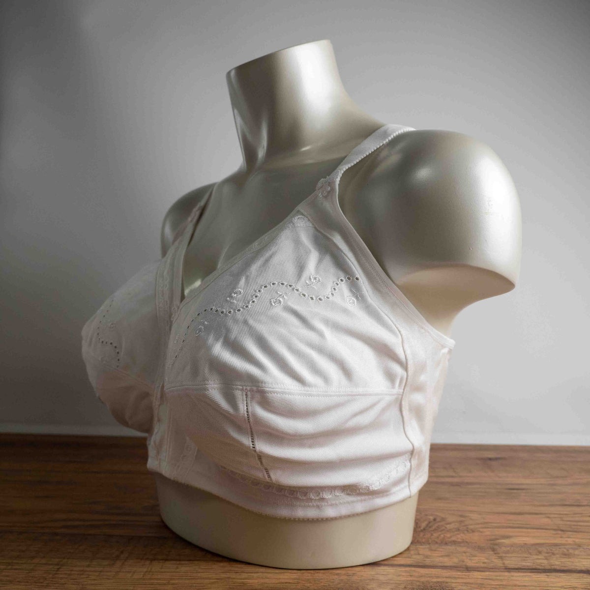 Triumph white blend bra with delicate embroidery, adjustable straps, and hook-and-eye closure.