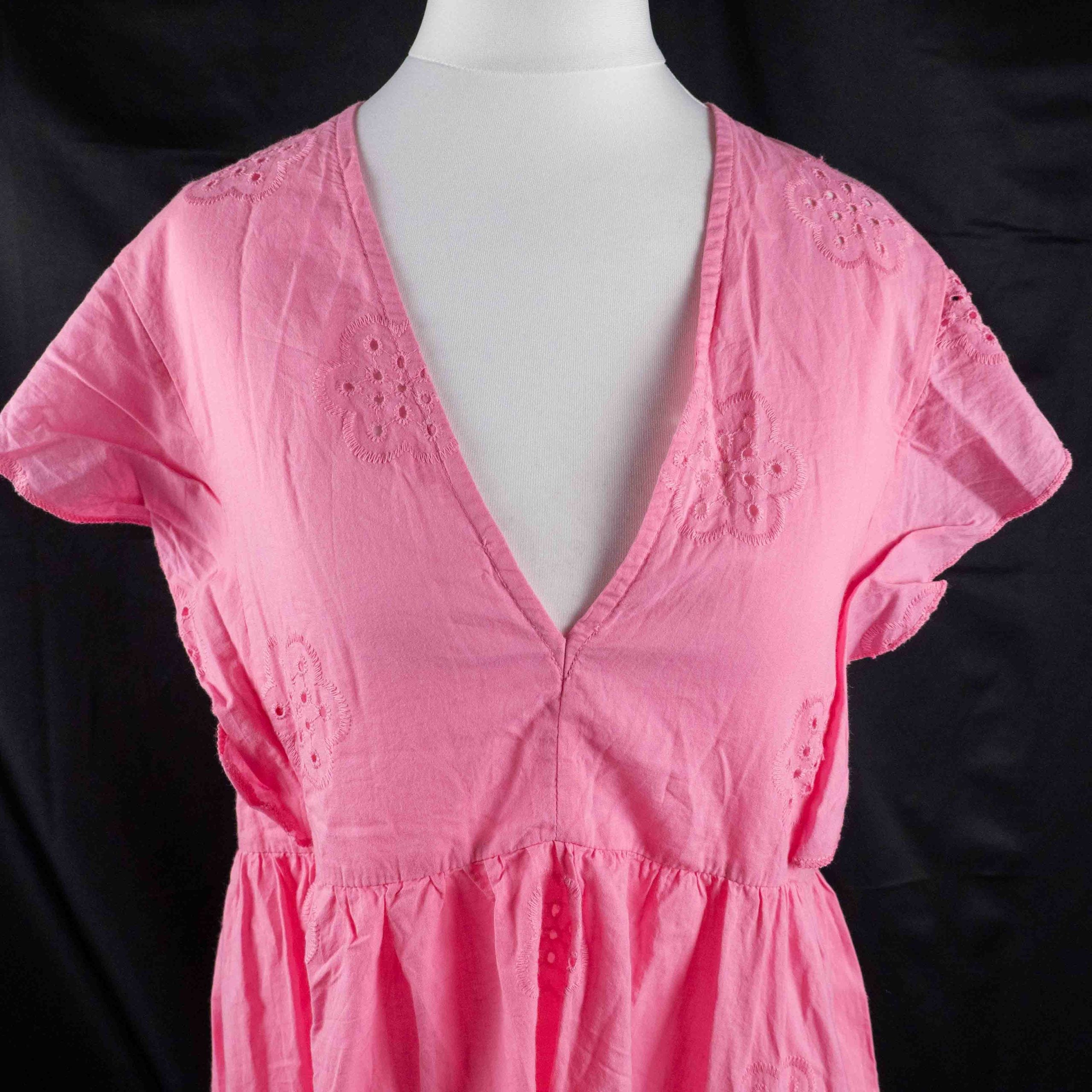Papaya pink casual dress with embroidered floral patterns and flutter sleeves.