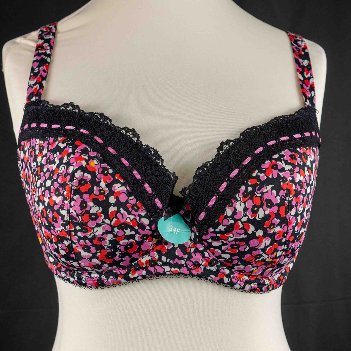 Debenhams pink and red floral bra with black lace trim and adjustable straps.