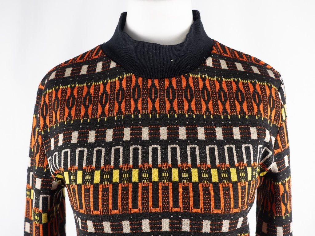 Zara black crewneck sweater with orange, yellow, and cream geometric pattern.