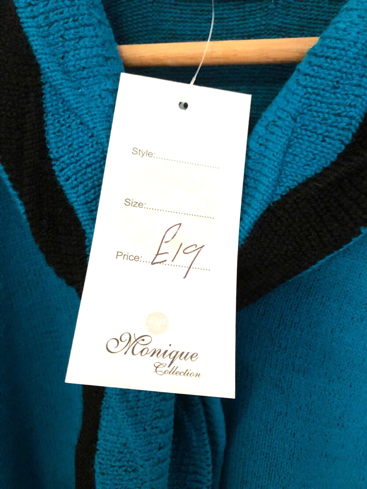 Monique green crewneck sweater with black mock scarf detail and toggle fastening.