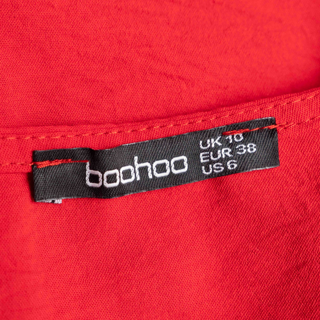 Boohoo red wrap crop top with floral print, ruffle cuffs, and tie-back design.