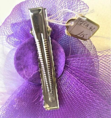 Purple fascinator with feathers and hair clip for special occasions.