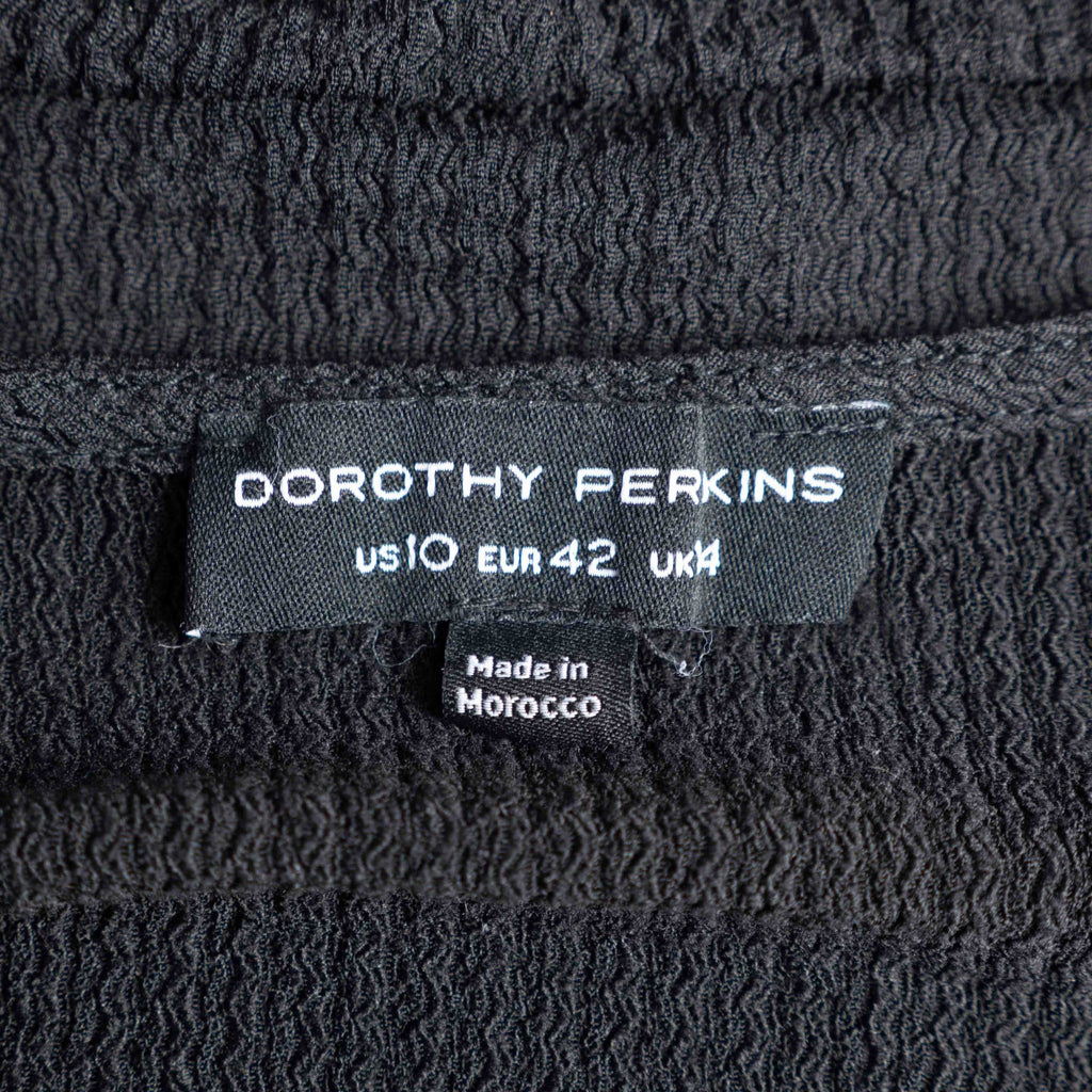 Dorothy Perkins black blouse with peplum hem and textured puff sleeves.