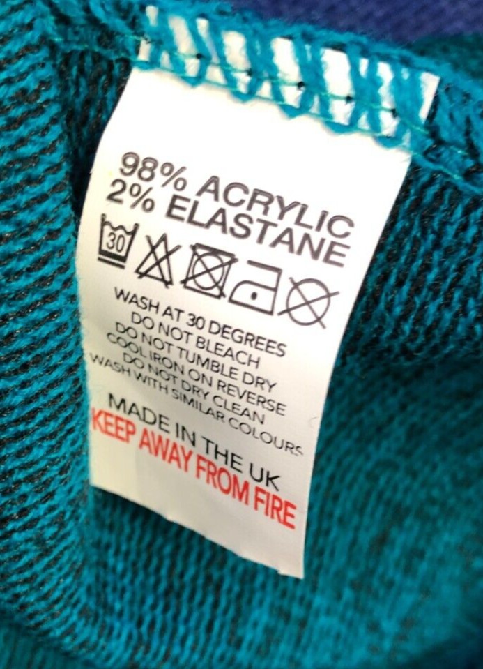 Monique green crewneck sweater with black mock scarf detail and toggle fastening.