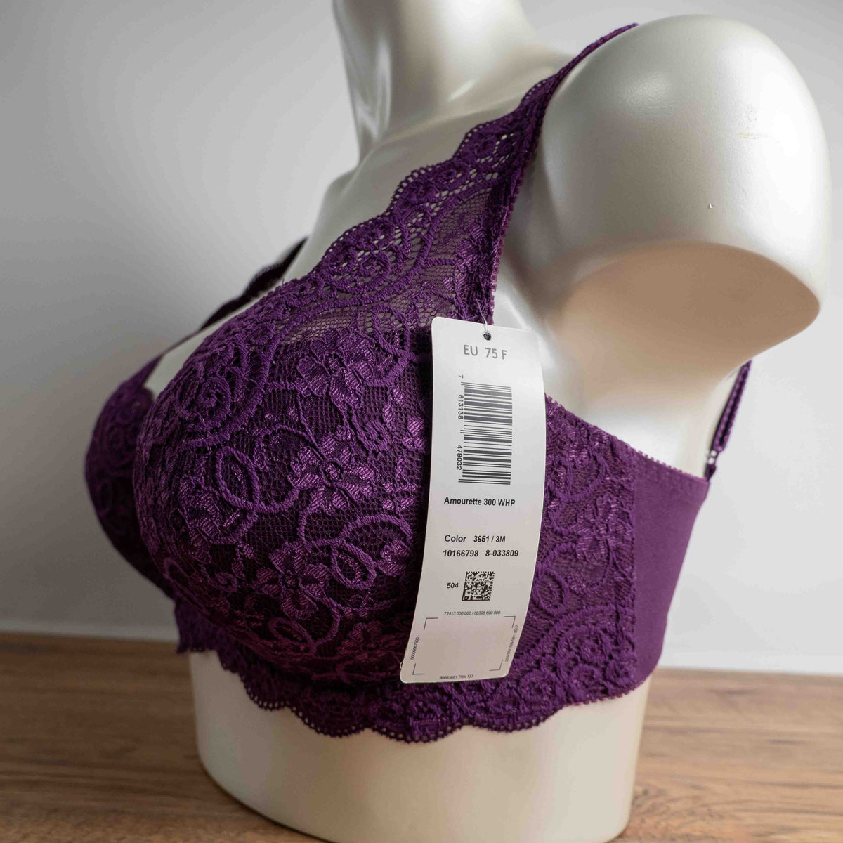 Triumph purple bra with floral lace pattern, adjustable straps, and hook-and-eye closure.