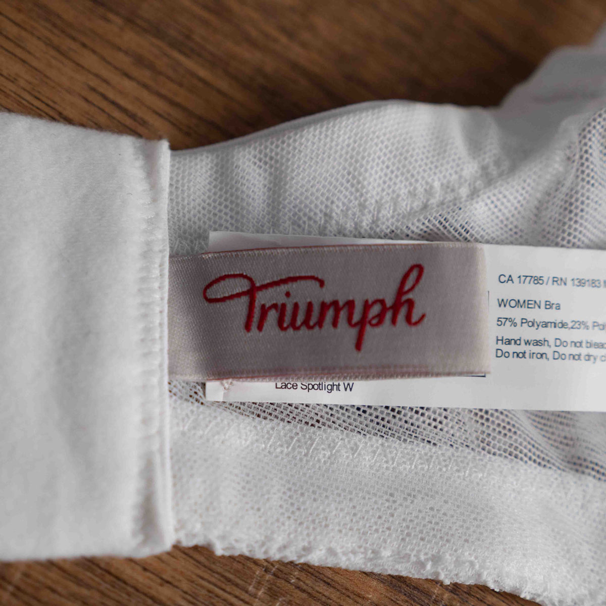 Triumph white lace soft cup bra with adjustable straps and lace-back detail.