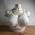 Triumph white blend bra with delicate embroidery, adjustable straps, and hook-and-eye closure.