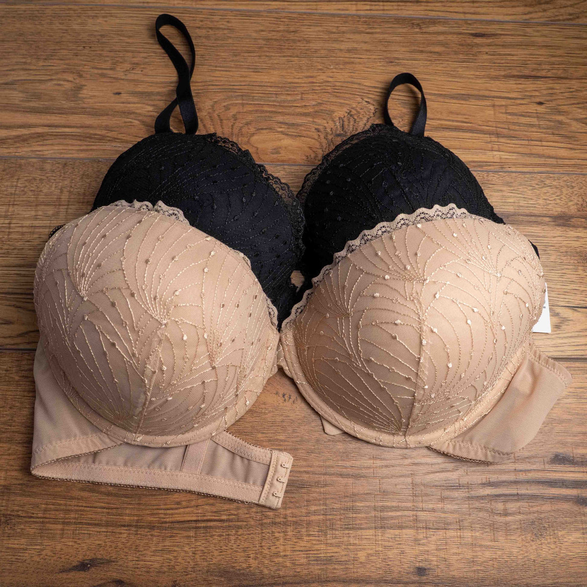 Wacoal beige and black underwired bras with floral lace design and adjustable straps.