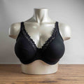 Next black plunge bra with lace trim, adjustable straps, and branded detailing.