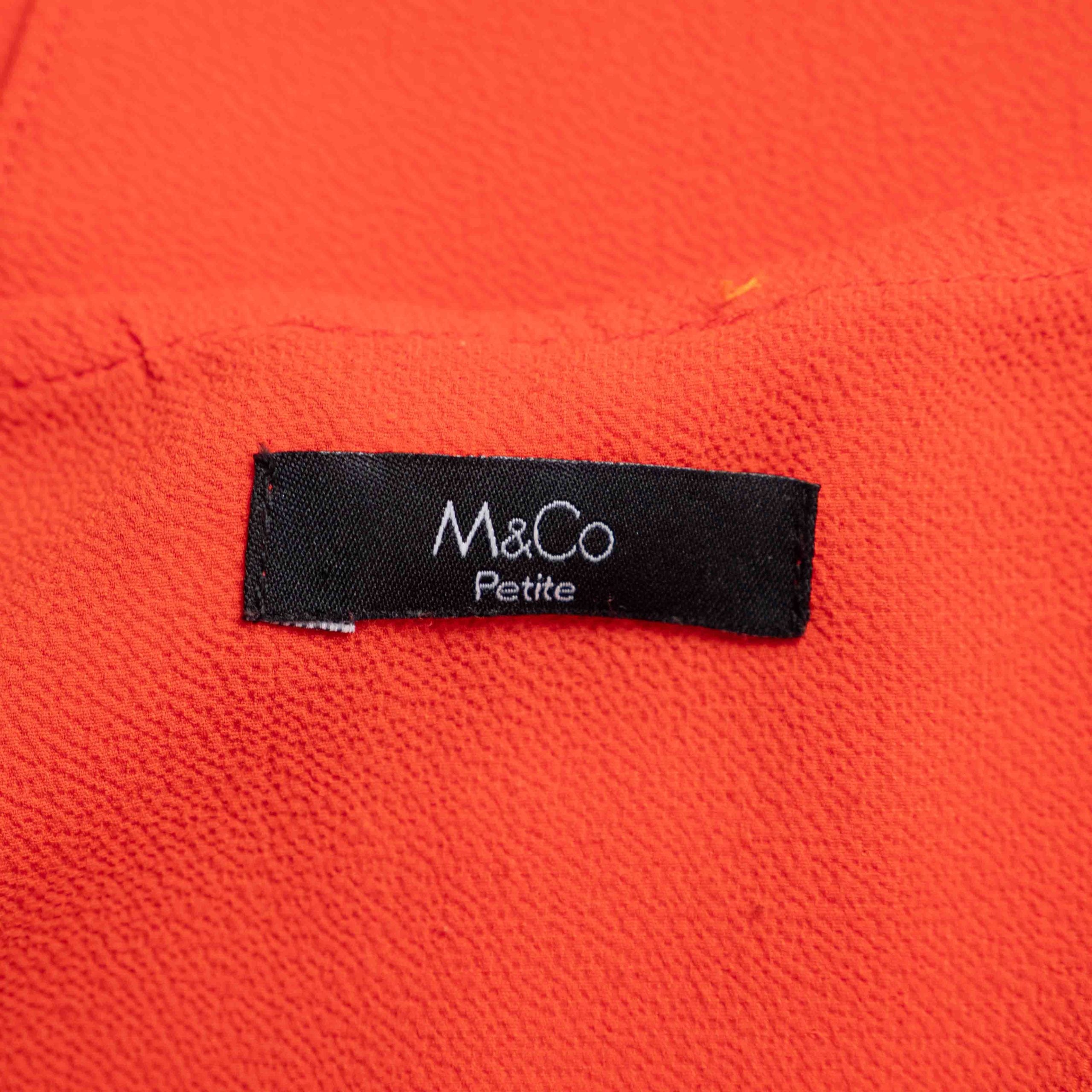 M&Co red layered blouse with short sleeves, made of polyester and elastane.