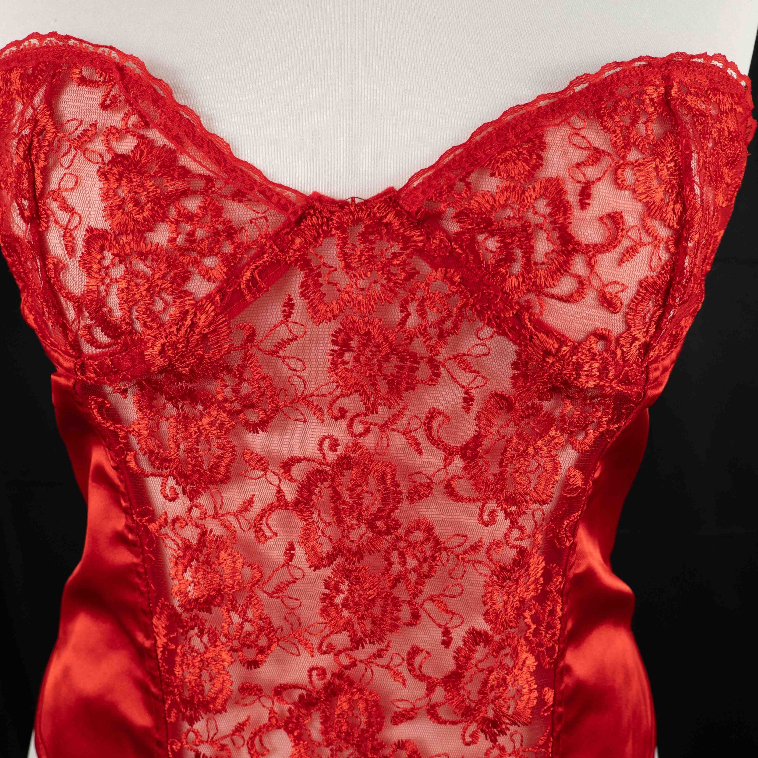 Red corset top with sheer floral lace bodice and satin sides, adjustable lace-up back.