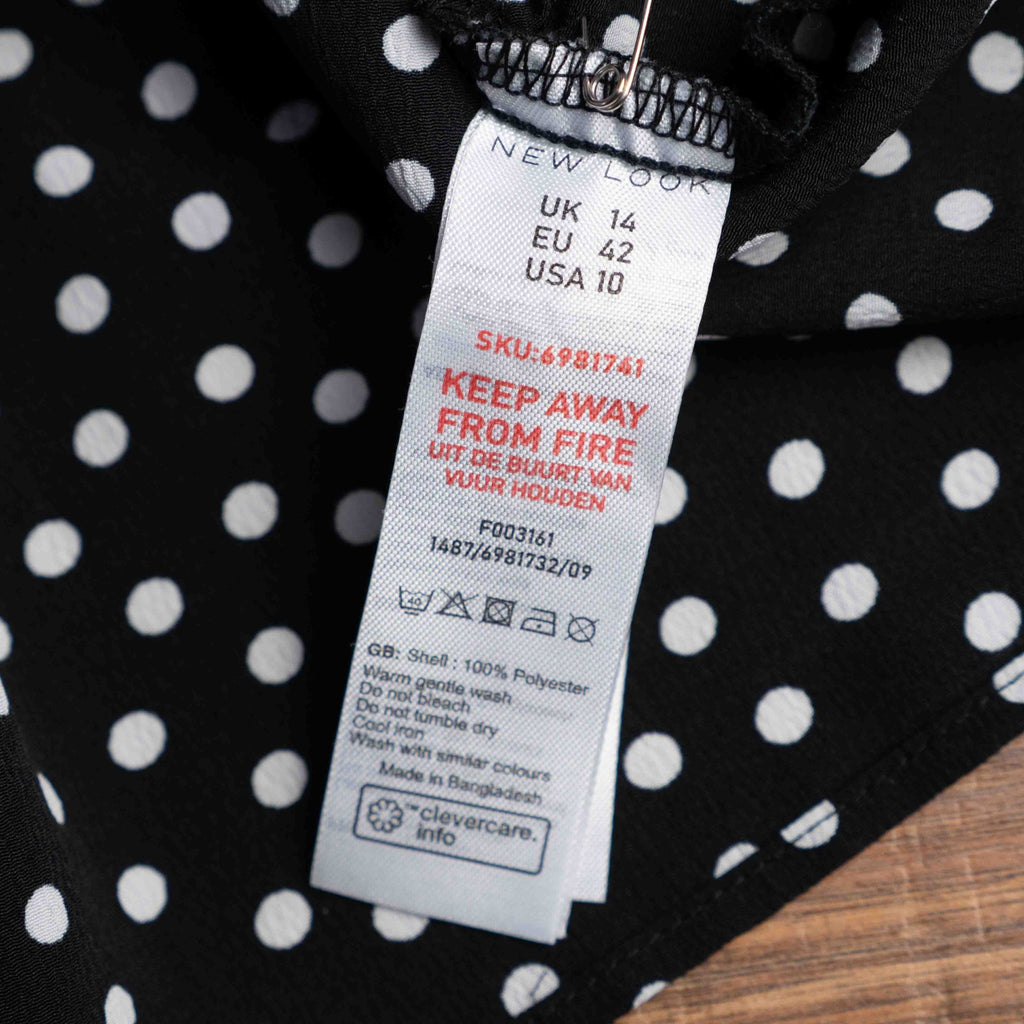 New Look black and white polka dot tunic blouse with V-neck and ruffled sleeves.