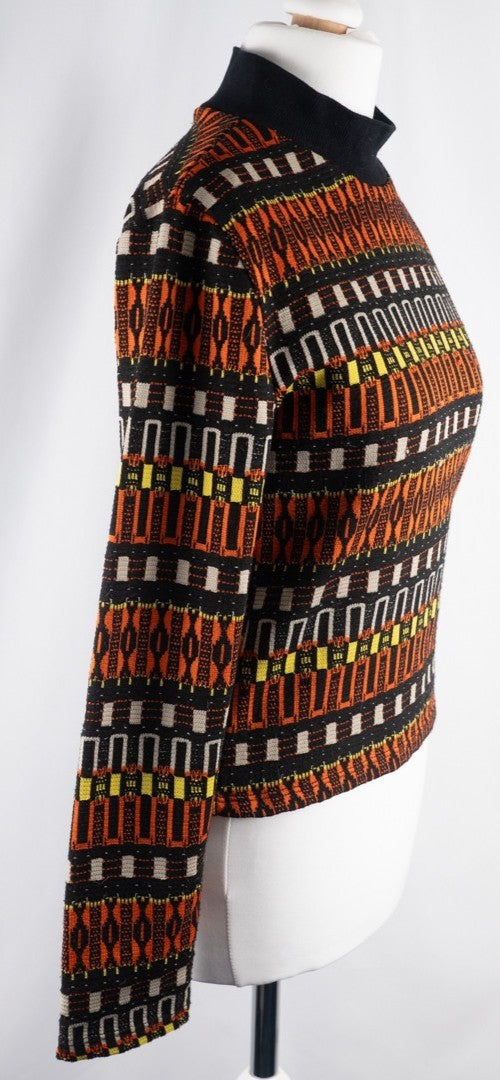 Zara black crewneck sweater with orange, yellow, and cream geometric pattern.
