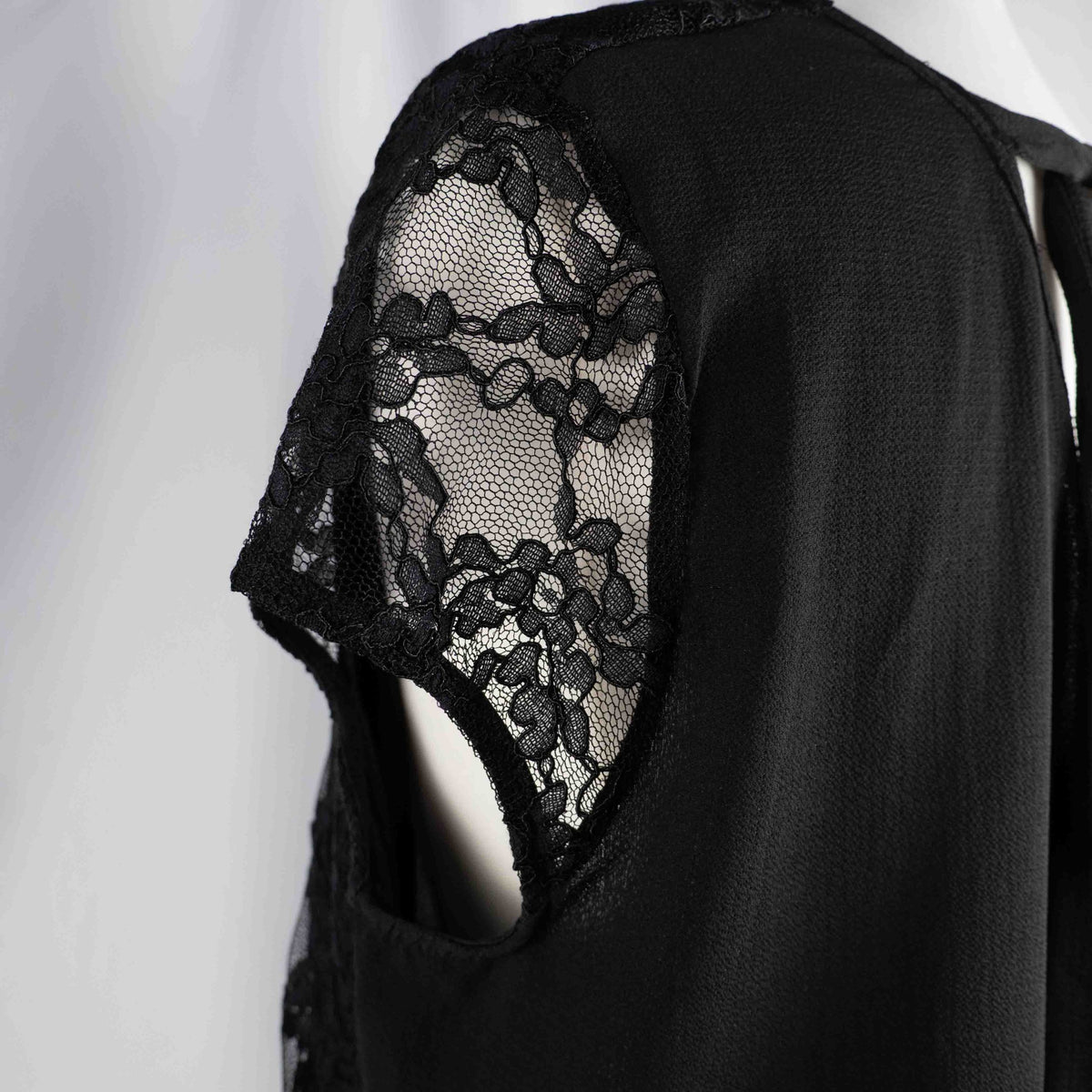 Black lace sleeve top with V neckline and tie-back detail, feminine style.