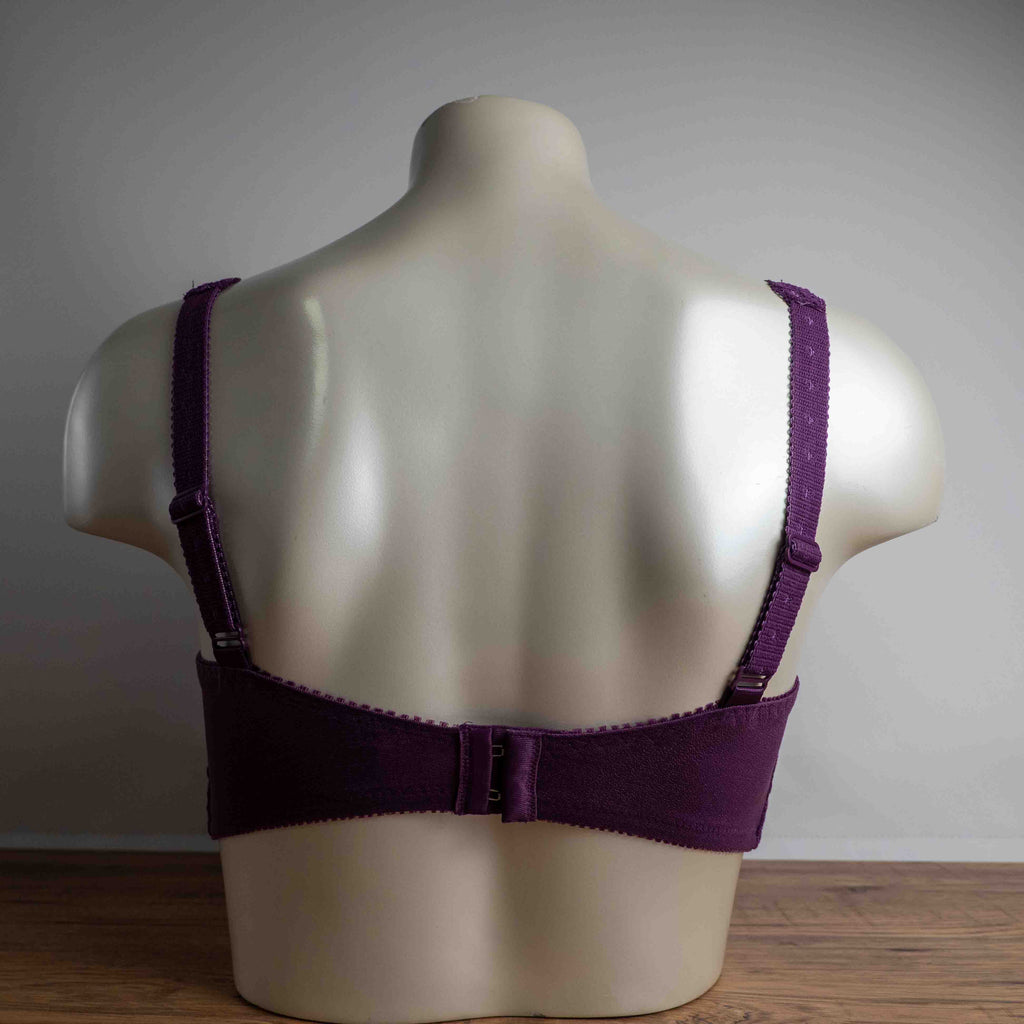 Triumph purple bra with floral lace pattern, adjustable straps, and hook-and-eye closure.