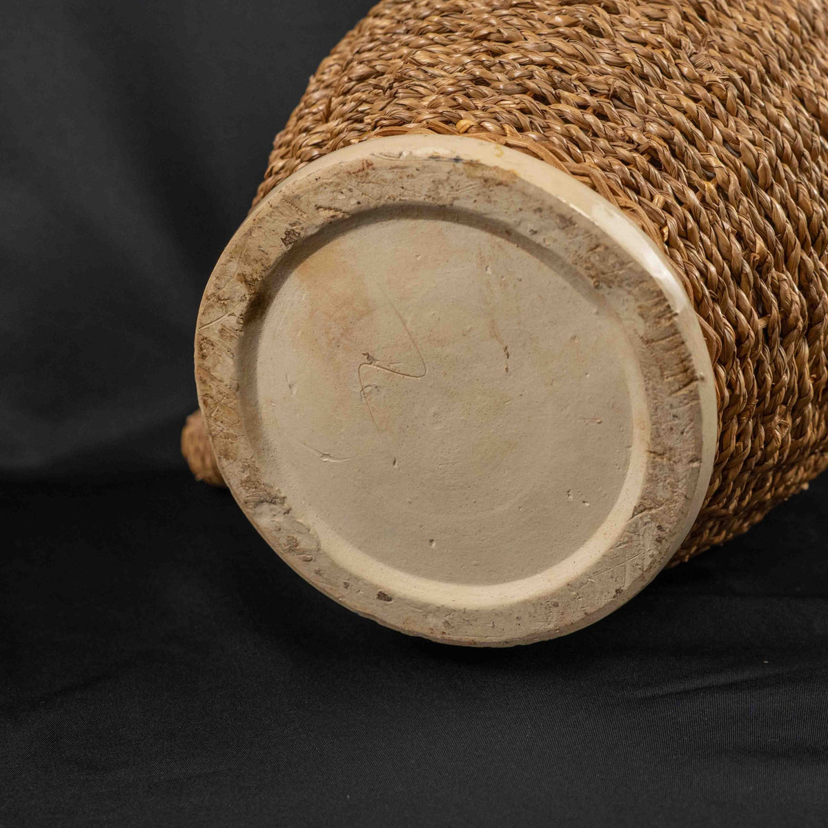 Ceramic pitcher jug beige and brown with wicker weave covering and rustic charm.