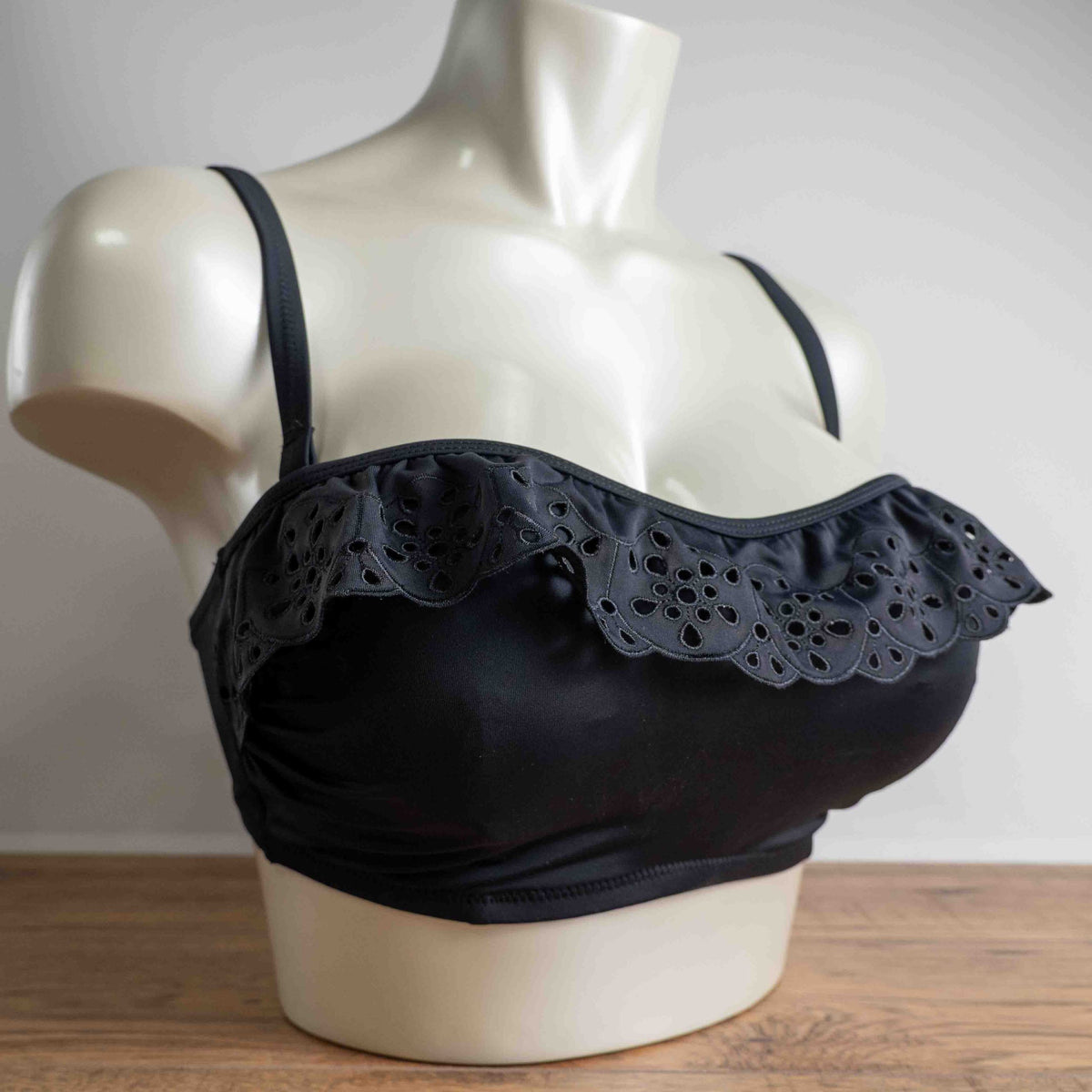 Pour Moi black bikini top with eyelet ruffle detail and adjustable straps.