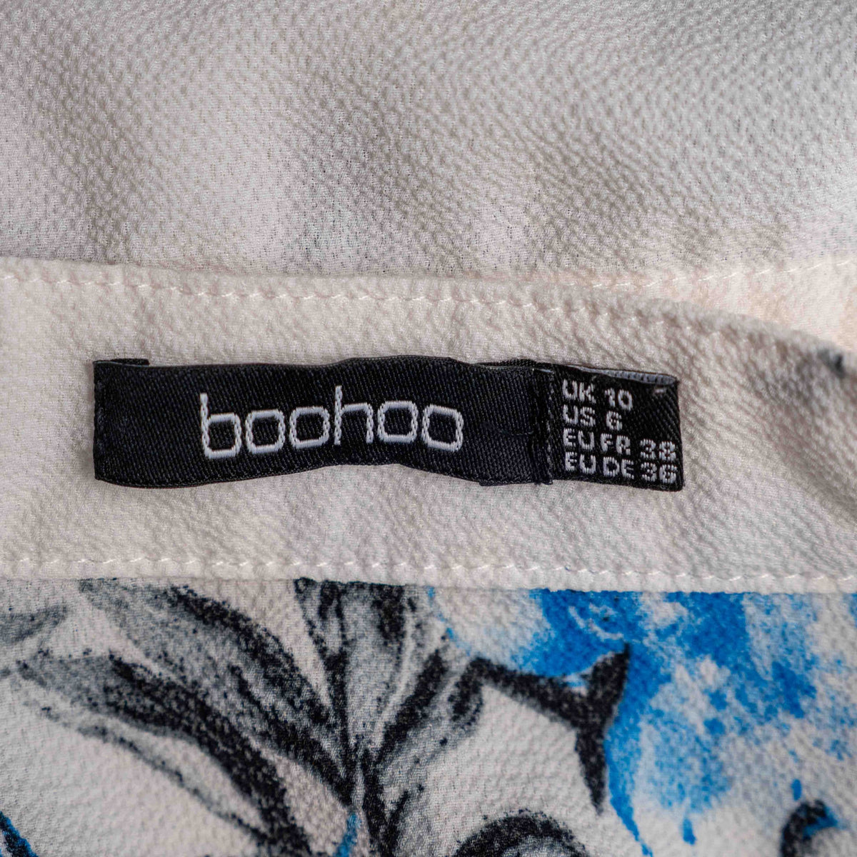 Boohoo white floral blouse with blue and pink prints, button front, drawstring waist.