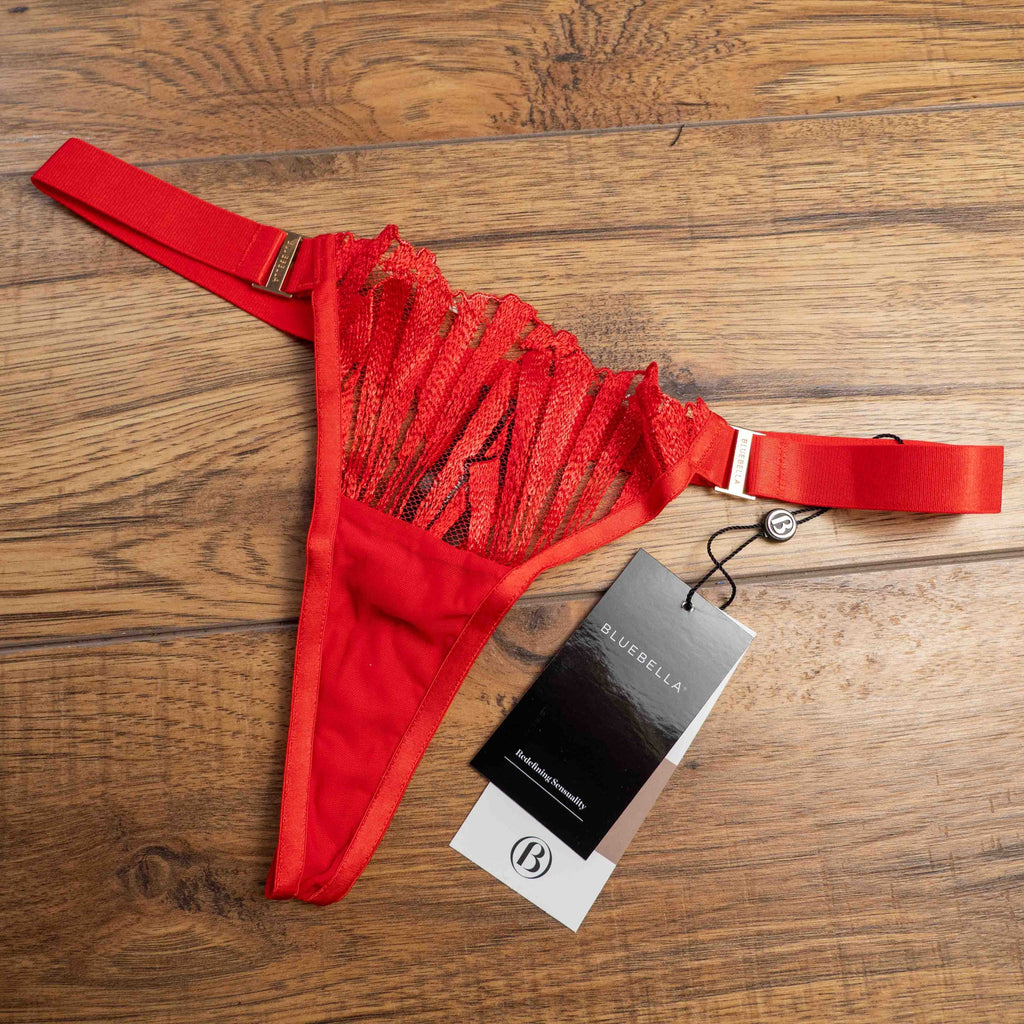 Bluebella red lace thong with elastic straps and brand tags attached.