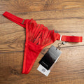 Bluebella red lace thong with elastic straps and brand tags attached.