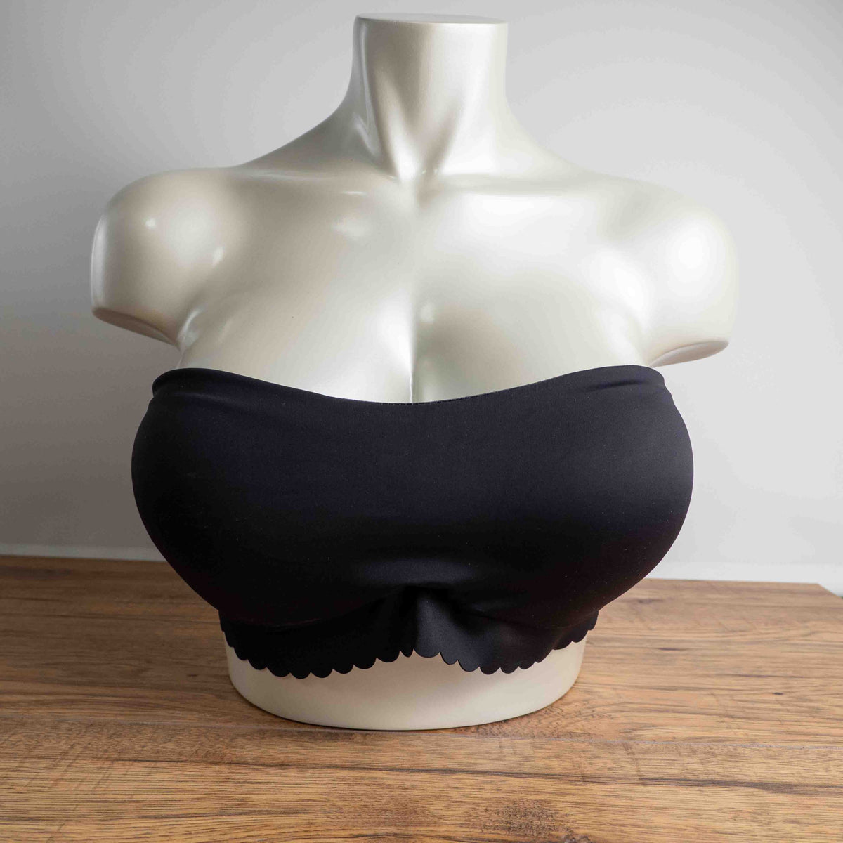 Next black strapless bandeau bra with scalloped hem and multiple hook back closure.