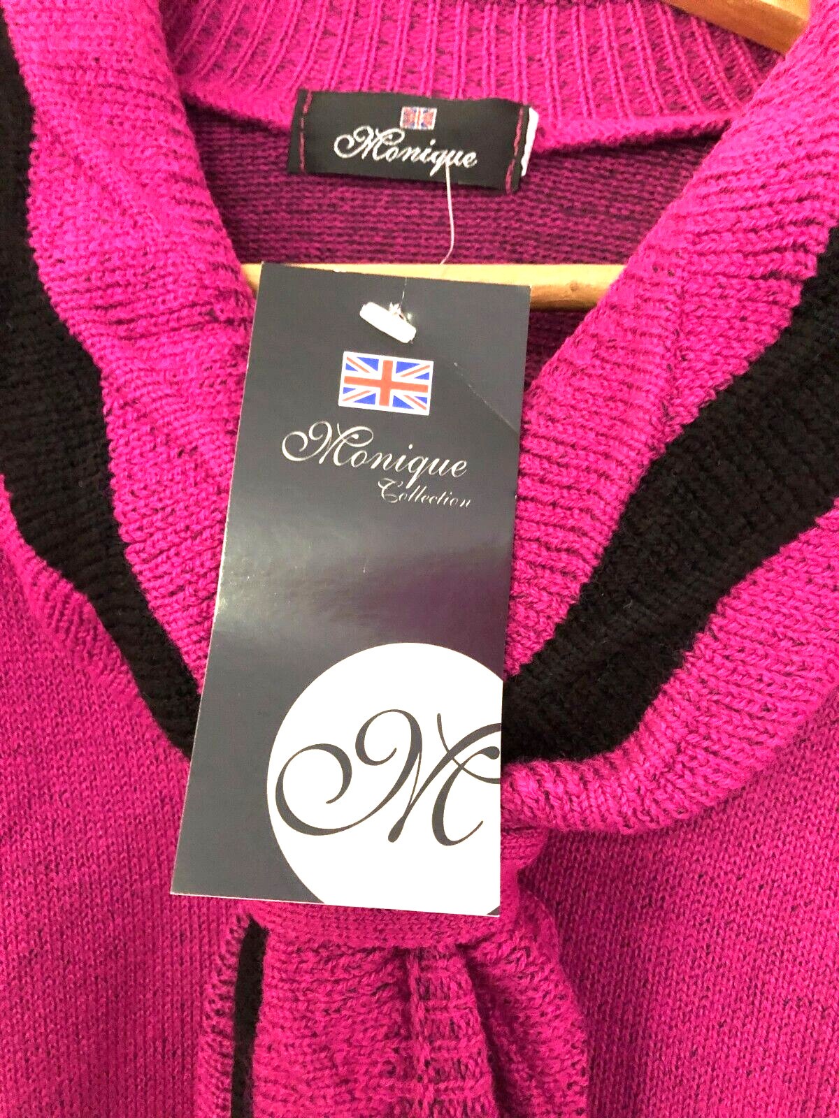 Monique pink crewneck sweater with mock scarf detail and toggle fastening.