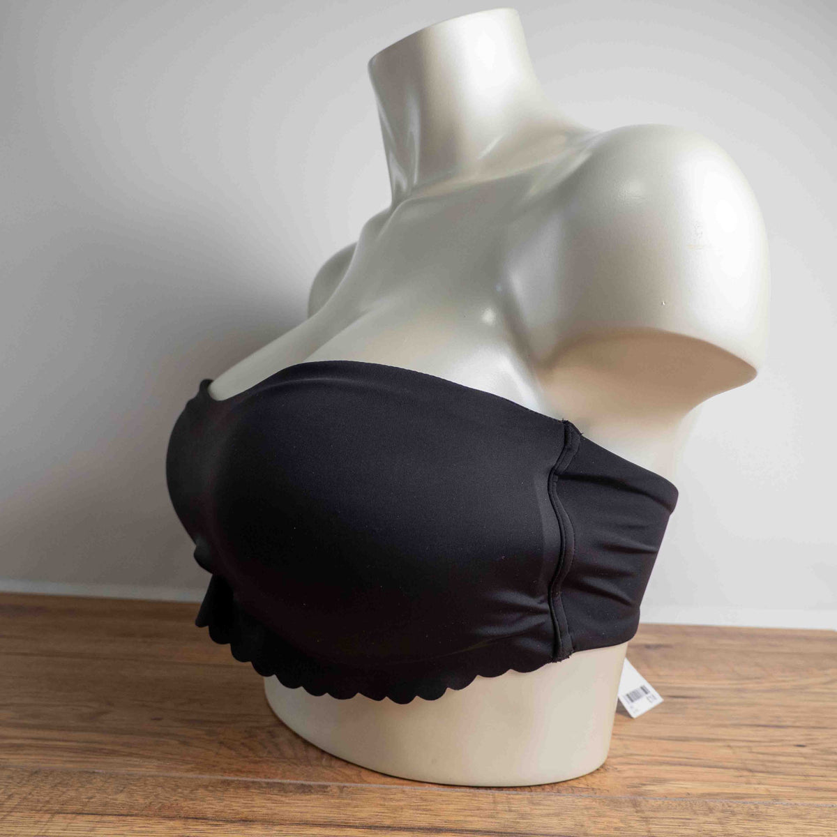 Next black strapless bandeau bra with scalloped hem and multiple hook back closure.
