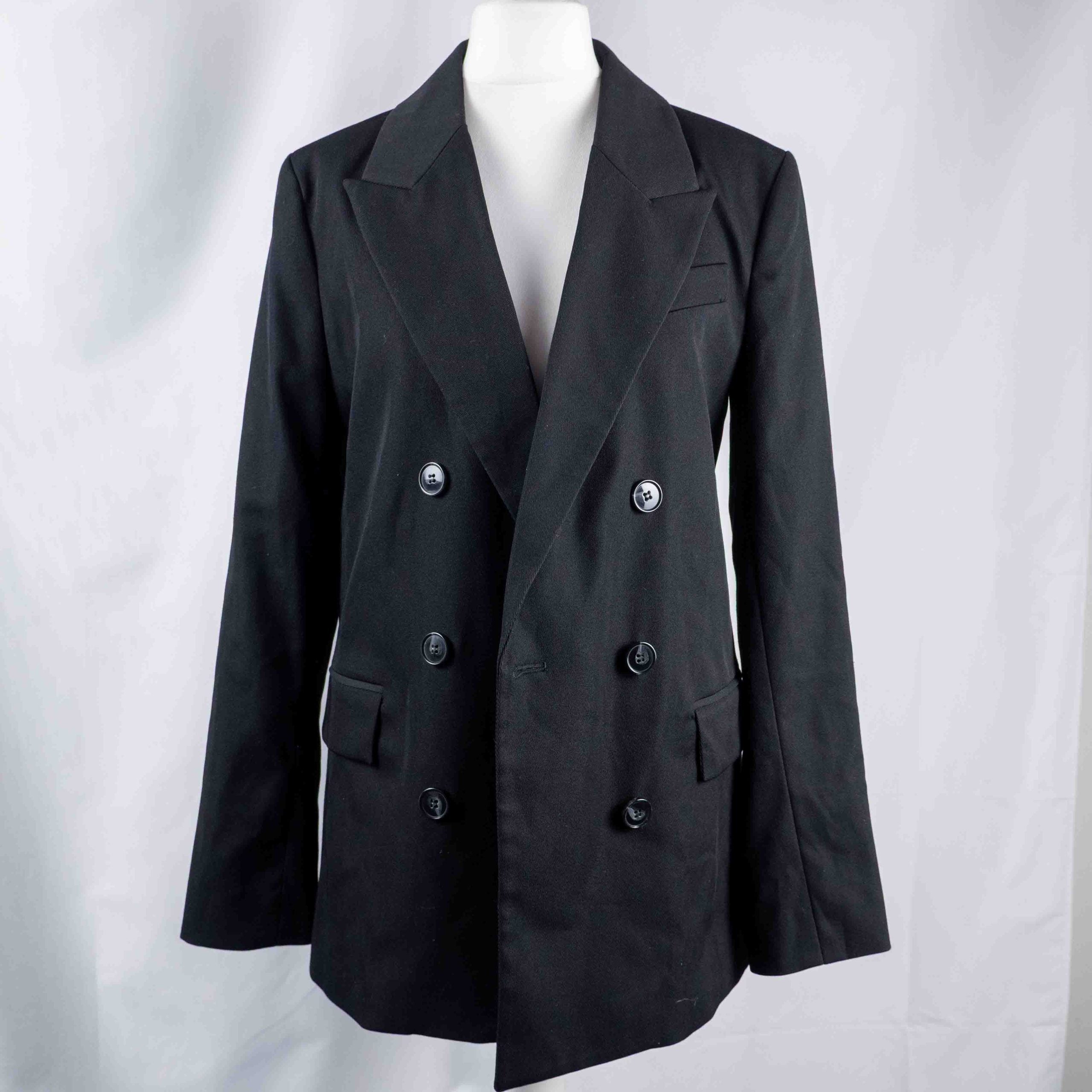 H&M black double-breasted blazer with structured lapel and six front buttons.