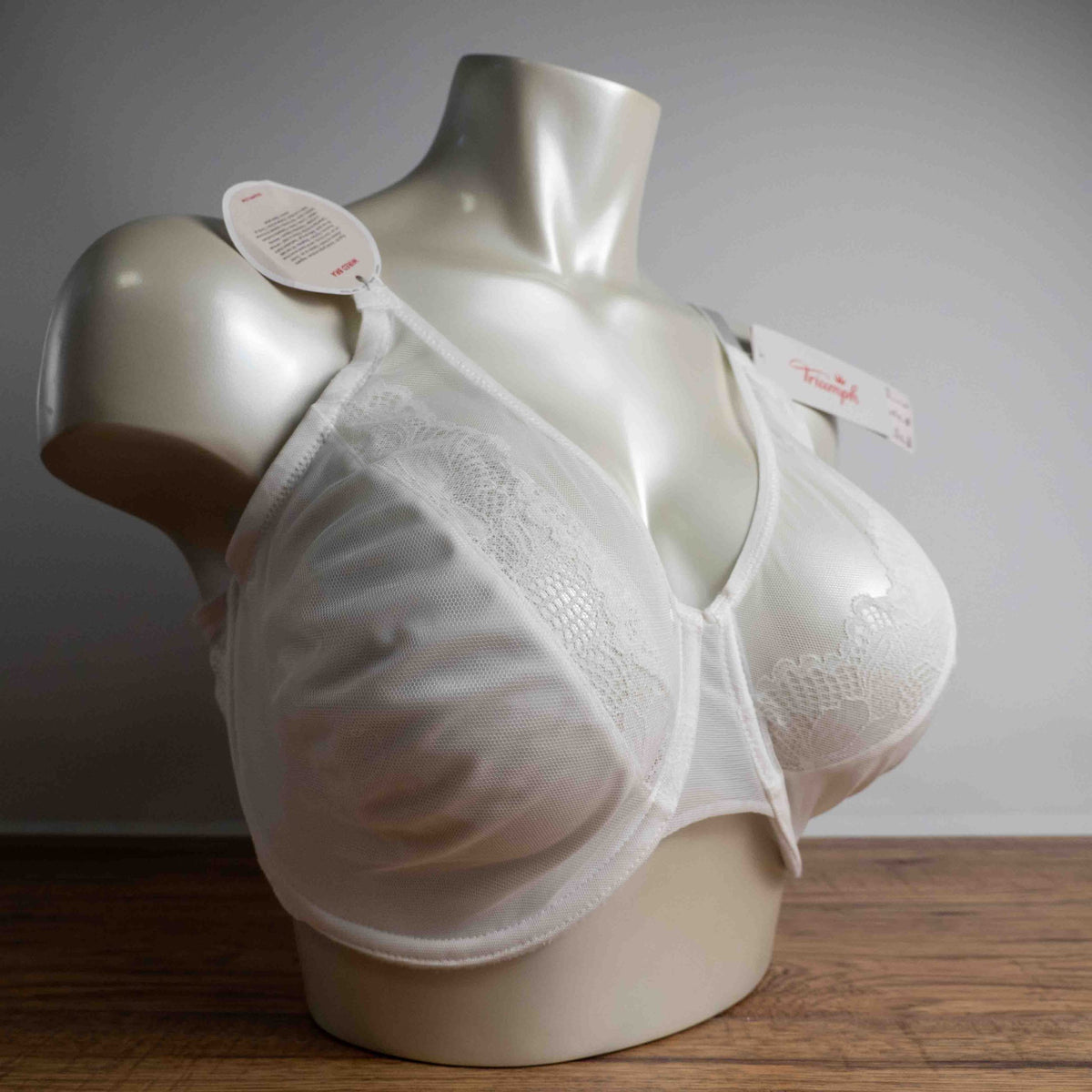 Triumph white lace soft cup bra with adjustable straps and lace-back detail.