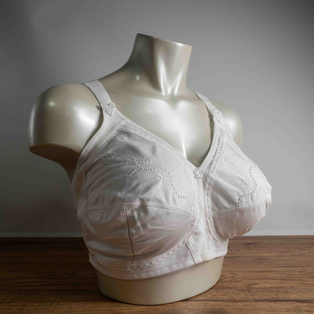 Triumph white blend bra with delicate embroidery, adjustable straps, and hook-and-eye closure.