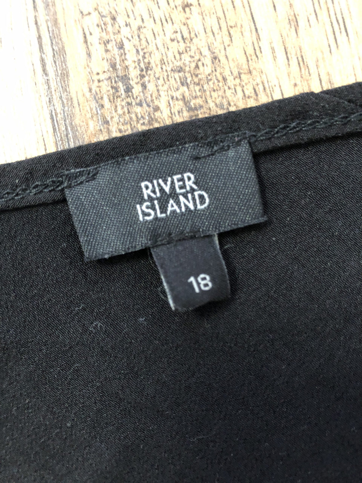River Island black peplum cami top with button details and adjustable straps.