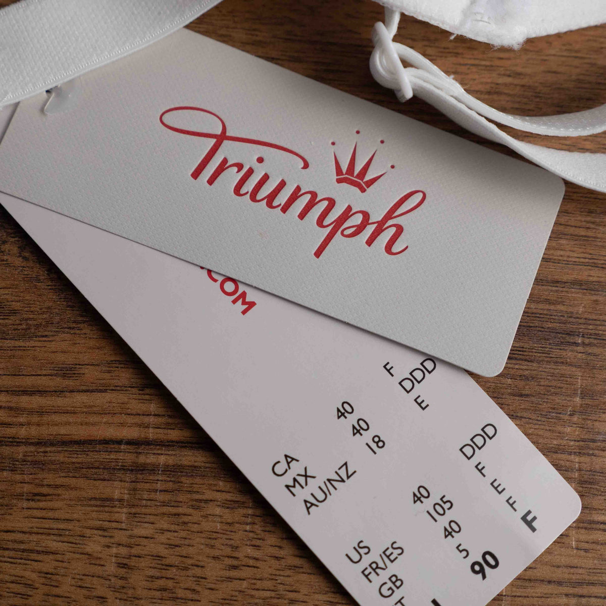 Triumph white lace soft cup bra with adjustable straps and lace-back detail.