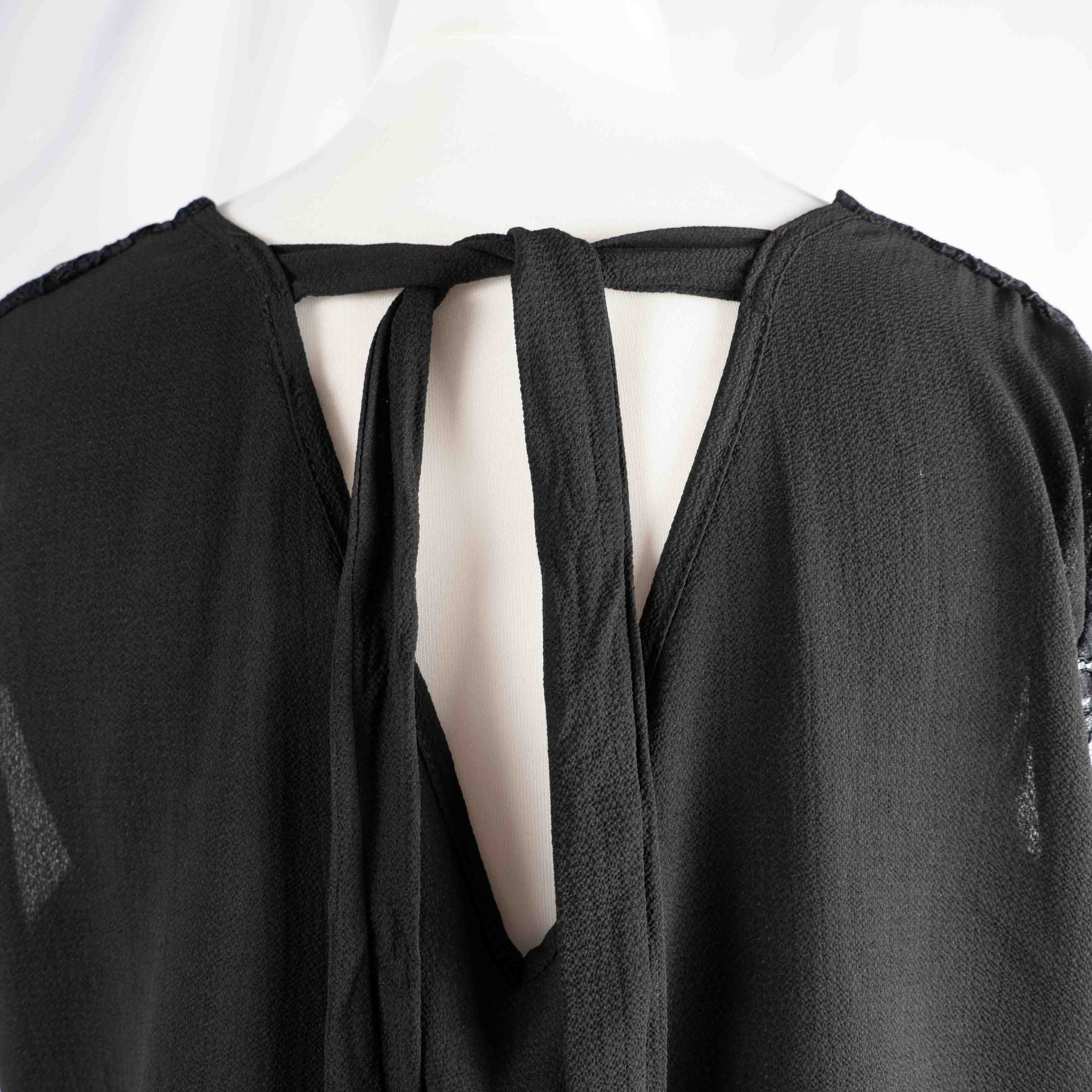 Black lace sleeve top with V neckline and tie-back detail, feminine style.