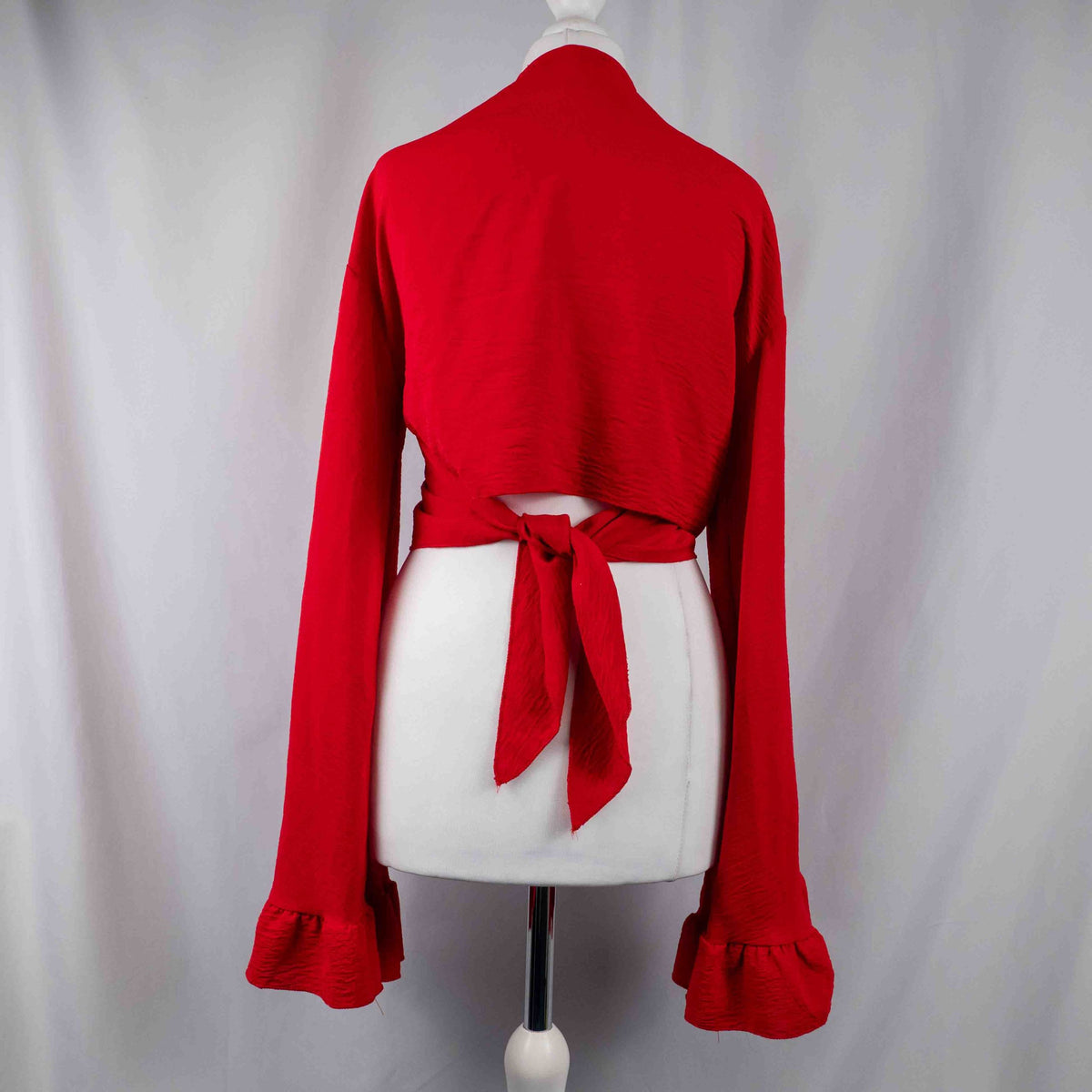 Boohoo red wrap crop top with floral print, ruffle cuffs, and tie-back design.