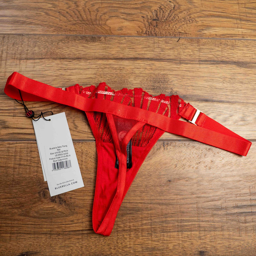 Bluebella red lace thong with elastic straps and brand tags attached.