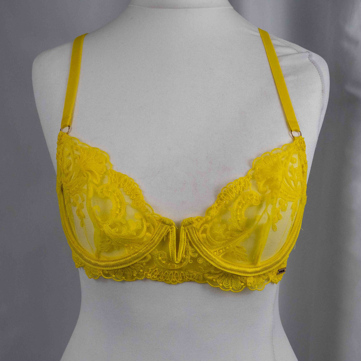 Bluebella yellow sheer lace bra with floral pattern and adjustable straps.